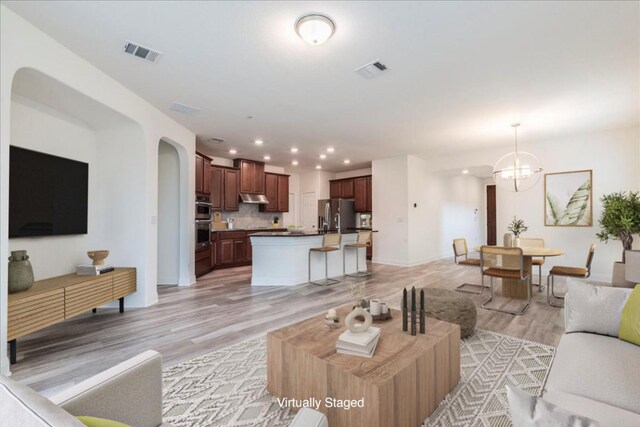 living room featuring recessed lighting, baseboards, light wood finished floors, and visible vents
