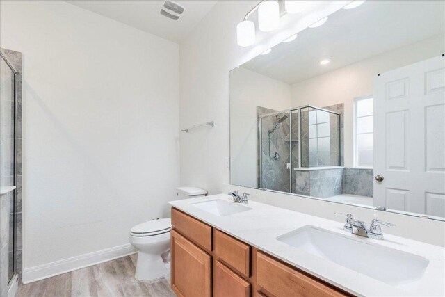 full bath featuring wood finished floors, toilet, a sink, and a stall shower