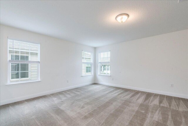 carpeted spare room with baseboards