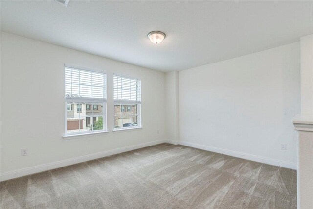 carpeted empty room with baseboards