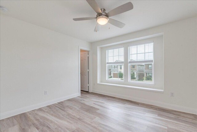 unfurnished room featuring baseboards, a ceiling fan, and light wood finished floors