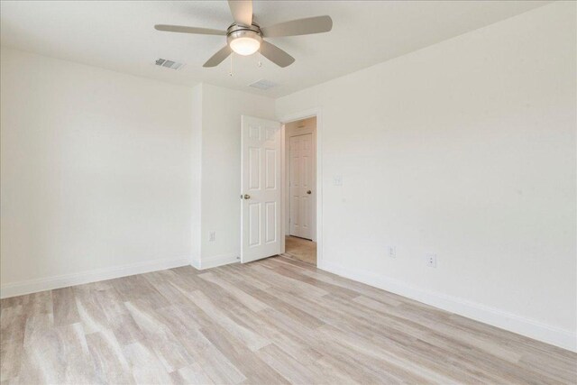 unfurnished room with baseboards, a ceiling fan, light wood finished floors, and visible vents