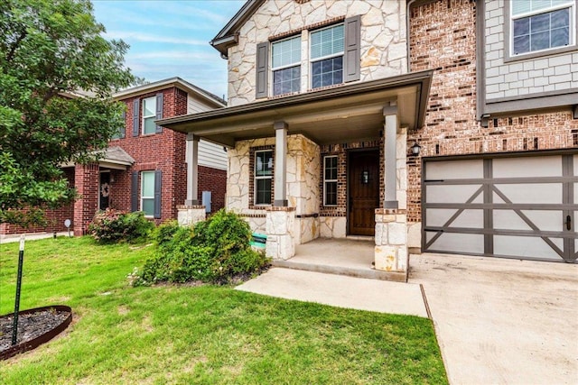 exterior space with covered porch, stone siding, a front yard, an attached garage, and driveway
