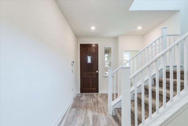 foyer featuring stairway, baseboards, recessed lighting, and wood finished floors