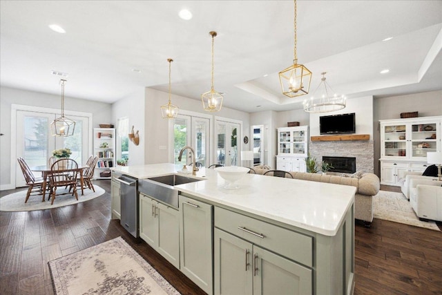 kitchen with a wealth of natural light, a sink, an island with sink, and dishwasher