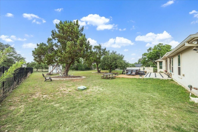 view of yard with a fenced backyard, an outbuilding, a patio area, and a shed