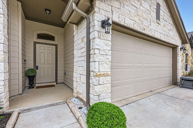 property entrance featuring a garage and stone siding