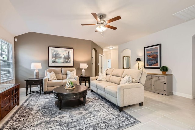 304 La Joya Pass, Leander, TX 78641 - living area with arched walkways, a ceiling fan, lofted ceiling, light tile patterned flooring, and baseboards