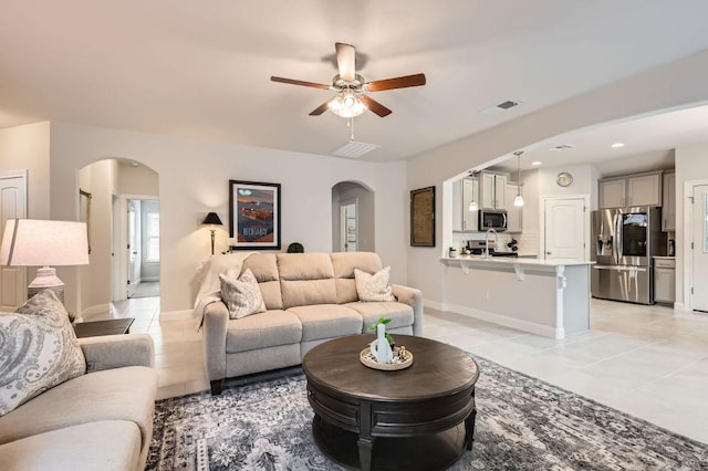 304 La Joya Pass, Leander, TX 78641 - living room featuring arched walkways, ceiling fan, light tile patterned flooring, baseboards, and recessed lighting