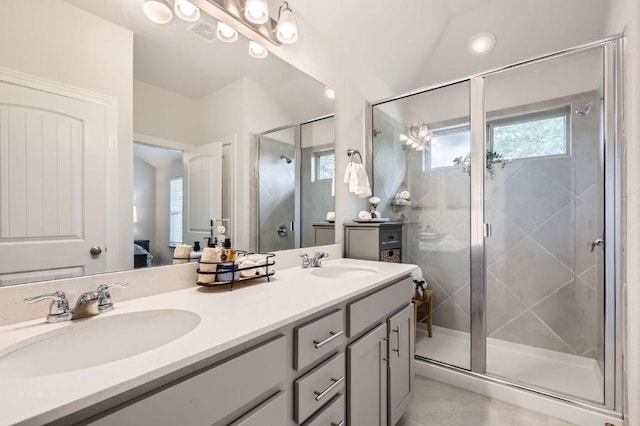 bathroom with double vanity, a shower stall, a sink, and ensuite bath
