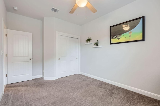 unfurnished bedroom with visible vents, a closet, baseboards, ceiling fan, and carpet