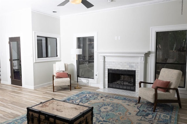 living room featuring baseboards, a ceiling fan, wood finished floors, and ornamental molding