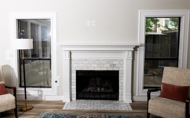 living area with baseboards, wood finished floors, and a fireplace