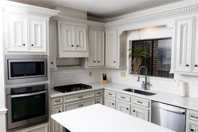 kitchen with light countertops, a sink, backsplash, and stainless steel appliances