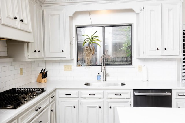 kitchen with light countertops, white cabinets, a sink, backsplash, and stainless steel appliances