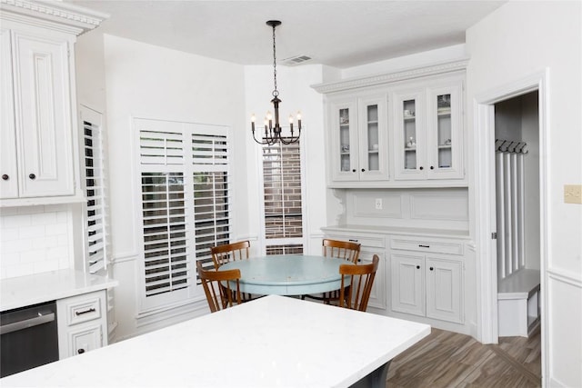 dining space featuring a notable chandelier, wood finished floors, and visible vents
