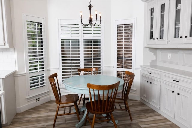 dining area featuring baseboards, a notable chandelier, and light wood-type flooring