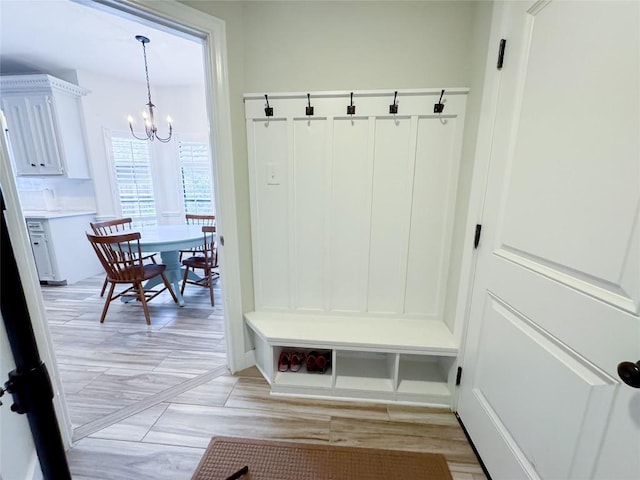 mudroom with an inviting chandelier and light wood-style flooring