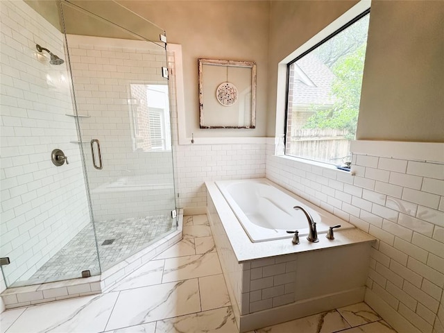 full bath with a bath, tile walls, a stall shower, a wainscoted wall, and marble finish floor