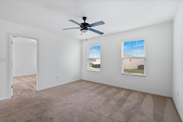 carpeted empty room with baseboards and ceiling fan