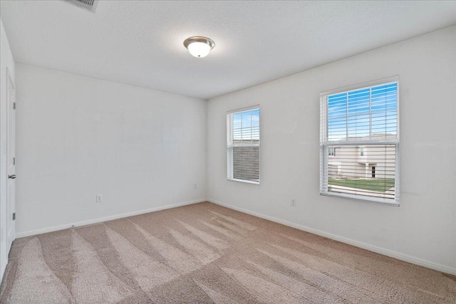 unfurnished room with baseboards and carpet