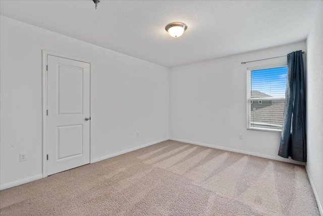 empty room with carpet floors and baseboards