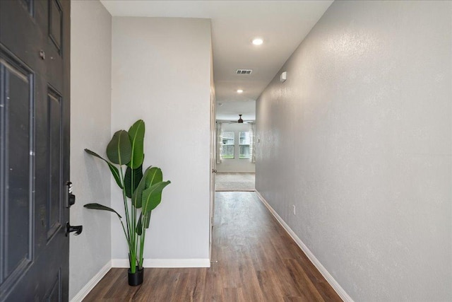 hallway with recessed lighting, baseboards, visible vents, and wood finished floors