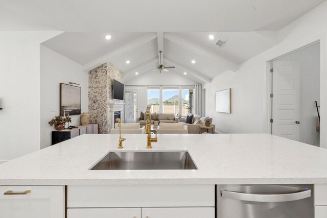 kitchen featuring light stone counters, a sink, white cabinetry, stainless steel dishwasher, and visible vents
