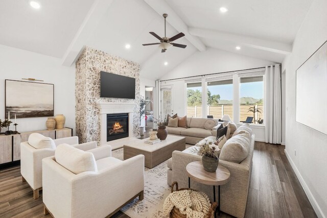 living area with ceiling fan, lofted ceiling with beams, a large fireplace, recessed lighting, and wood finished floors