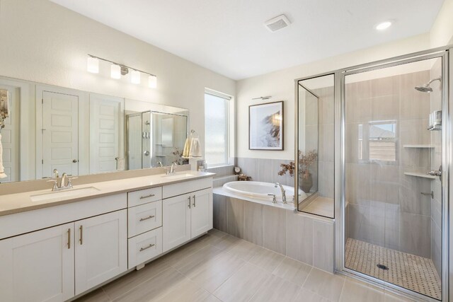 full bathroom featuring a garden tub, double vanity, tile patterned floors, a sink, and a stall shower