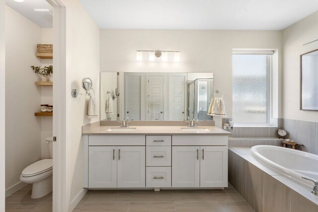 bathroom featuring a sink, tile patterned floors, toilet, and double vanity