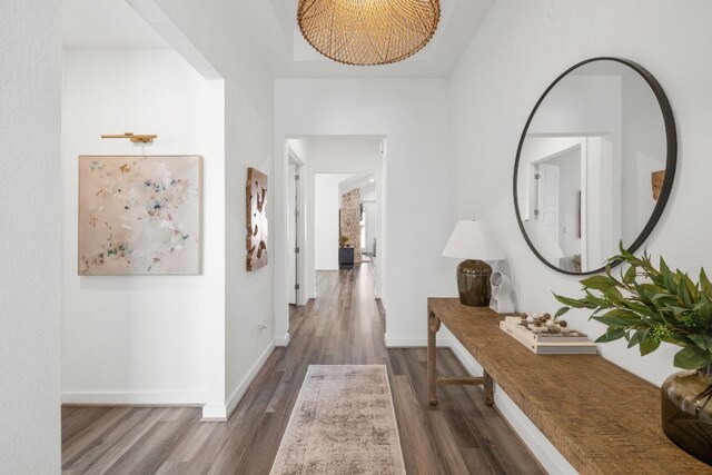 hall with baseboards and wood finished floors