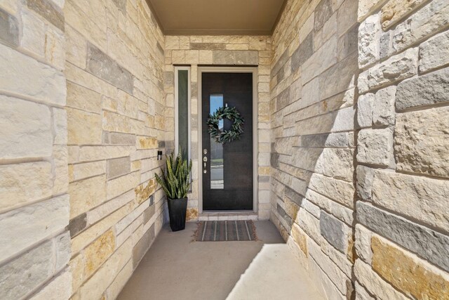 property entrance with stone siding