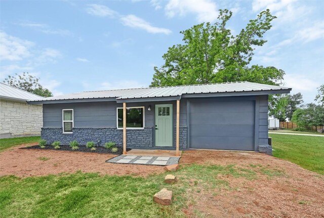 ranch-style house with a garage, dirt driveway, a front lawn, and stone siding