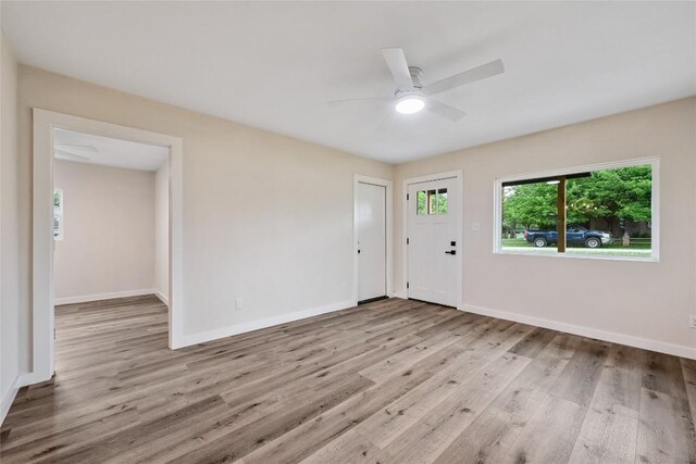 interior space featuring baseboards, a ceiling fan, and wood finished floors