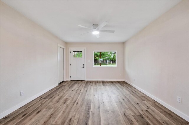 spare room with baseboards, ceiling fan, and wood finished floors