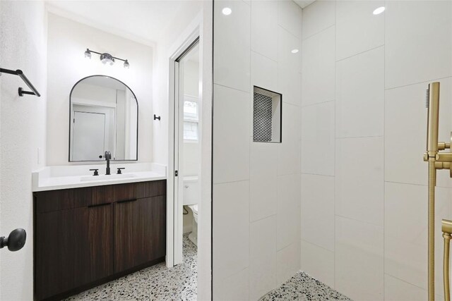bathroom with vanity, toilet, and speckled floor