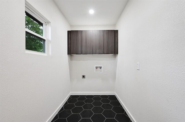 laundry area with dark tile patterned floors, hookup for an electric dryer, laundry area, washer hookup, and baseboards