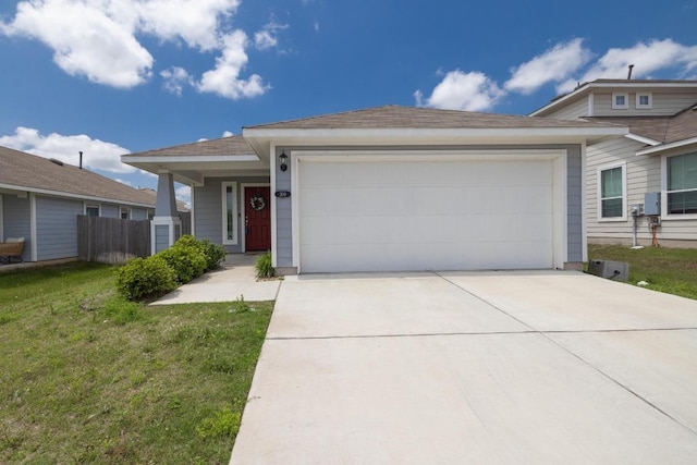 view of front of property featuring an attached garage, concrete driveway, and a front lawn