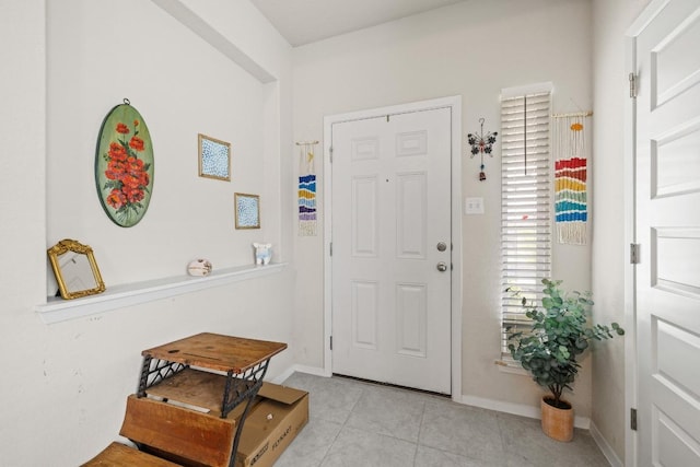foyer entrance featuring light tile patterned floors and baseboards