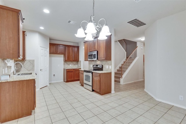 kitchen with stainless steel appliances, visible vents, decorative backsplash, and a sink
