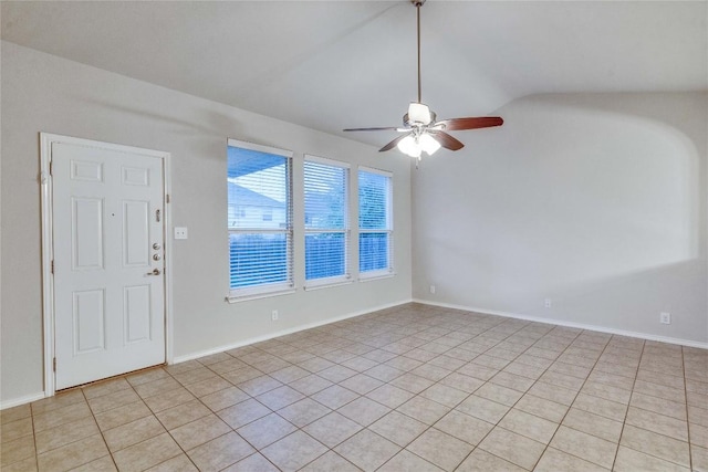 unfurnished room featuring baseboards, ceiling fan, lofted ceiling, and light tile patterned flooring