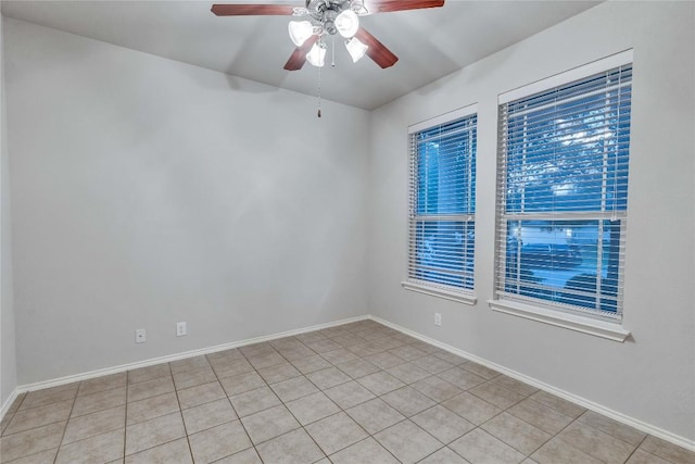 spare room with light tile patterned floors, baseboards, and ceiling fan