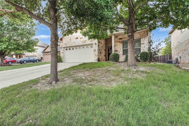 obstructed view of property featuring central air condition unit, driveway, stone siding, and a garage