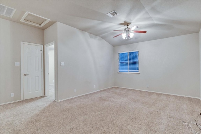 spare room with lofted ceiling, carpet flooring, and visible vents