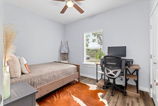 bedroom featuring baseboards, a ceiling fan, and wood finished floors