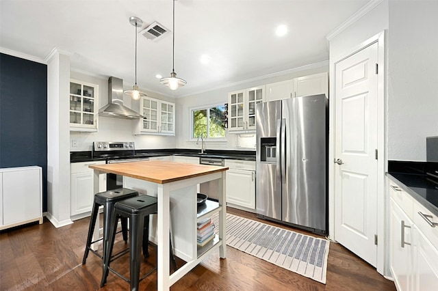 12218 Grimsley Dr, Austin, TX 78759 - kitchen with wall chimney range hood, crown molding, appliances with stainless steel finishes, visible vents, and butcher block counters