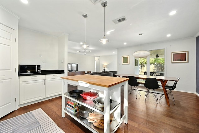 12218 Grimsley Dr, Austin, TX 78759 - kitchen featuring visible vents, open shelves, crown molding, black microwave, and wood counters