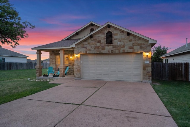 ranch-style home featuring a lawn, fence, concrete driveway, and stone siding