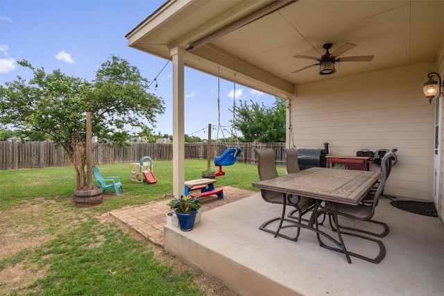 view of patio / terrace with a fenced backyard, a ceiling fan, outdoor dining area, and a playground